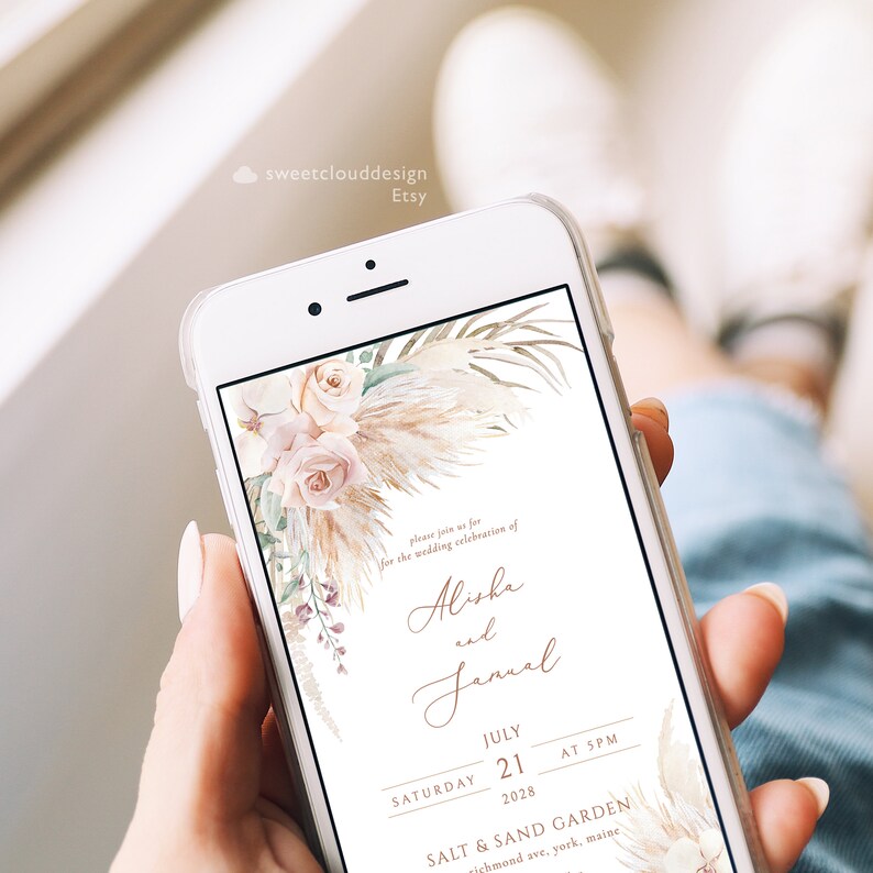 K&ouml;nnte beinhalten: Eine digitale Hochzeitseinladung mit einem Aquarell-Blumendesign mit rosafarbenen Rosen, Pampasgras und Gr&uuml;npflanzen. Der Text lautet: "Bitte feiern Sie mit uns die Hochzeit von Alisha und Jamal, Samstag, 21. Juli 2028, um 17:00 Uhr, Salt & Sand Garden, Richmond Ave, York, Maine."