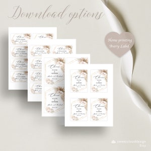 May include: Printable wedding favor tags with a boho theme. The tags feature a white background with gold geometric shapes, pampas grass, and white flowers. The text on the tags reads "Cheers to love and happiness".