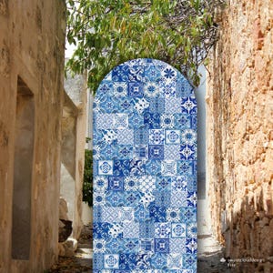 May include: A blue and white patterned archway made of tiles, set against a backdrop of two stone walls. The archway is a decorative element, possibly for a garden or home decor.