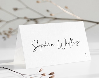 May include: White place card with the name "Sophia Willis" written in black cursive script. The number "1" is printed in the bottom right corner.