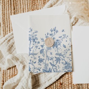 May include: A white envelope with a blue floral pattern and a wax seal. The envelope is on a woven surface.