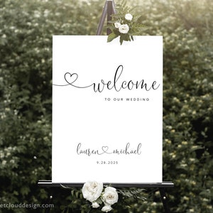 Könnte beinhalten: Weißes Hochzeitsschild mit schwarzem Kalligraphietext, der "Willkommen zu unserer Hochzeit" und "Lauren & Michael 9.28.2025" lautet.