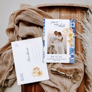 May include: Save the date card with a blue and white tile pattern border. The card features a photo of a couple in front of a floral arrangement. The text on the card reads "Save our date" and "09 12 25 Alisha Rogers & Sabatian Anderson York, Maine".