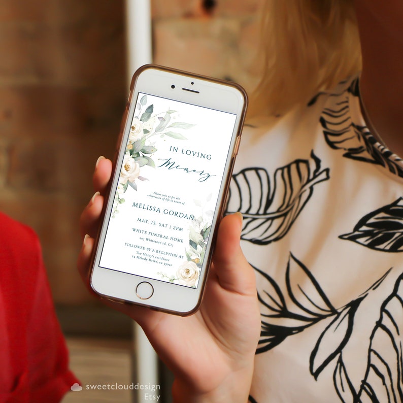 May include: A digital invitation on a smartphone screen for a memorial service for Melissa Gordan. The invitation features a watercolor floral design with white flowers and green leaves. The text reads "In Loving Memory, Melissa Gordan, May 15, Sat 2PM, White Funeral Home, 991 Whiteside Rd, CA, Followed by a Reception at The Melody's residence at 44 Melody Drive, CA 19000."
