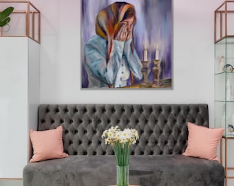 May include: A painting of a woman in a blue and orange headscarf, with her hands covering her face, sitting in front of two lit candles on a table.
