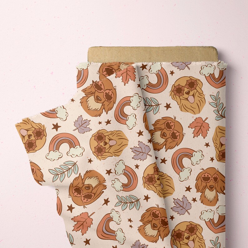 May include: A beige fabric with a repeating pattern of brown dogs wearing sunglasses, rainbows, and stars. The fabric is folded in half, showing the pattern on both sides.