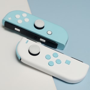 May include: Two Nintendo Switch Joy-Con controllers, one in light blue with white buttons and one in white with light blue buttons.