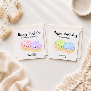 May include: Two square white birthday cards with envelopes. The left card reads Happy Birthday to our amazing granddaughter and Charlotte, featuring two pink and purple dumpling illustrations. The right card reads Happy Birthday to our amazing son and Henry, featuring green and blue dumpling illustrations.