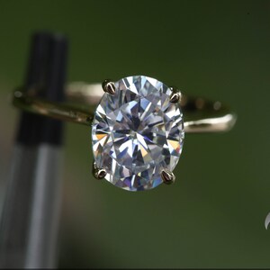 Pu&ograve; includere: Un anello d'oro con un grande diamante rotondo e trasparente.