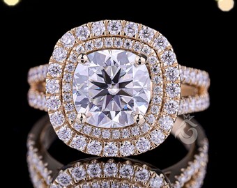 May include: A gold engagement ring featuring a large, square-cut diamond centre stone, encircled by a double halo of smaller diamonds. The band also has diamond accents. The ring is set against a black background with bokeh lights.