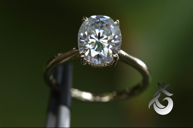 Pu&ograve; includere: Un anello d'argento con un grande diamante ovale trasparente.