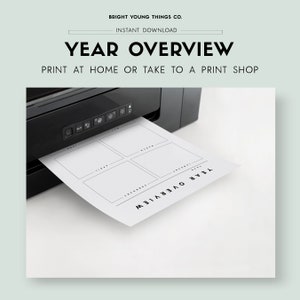 May include: A black and white printable year overview planner with six sections for each month of the year. The planner is being printed from a black printer.