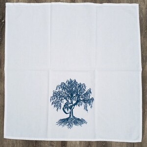 May include: White tea towel with a blue embroidered design of a tree with a guitar in its branches.