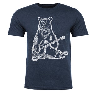 May include: A navy blue t-shirt with a white illustration of a bear playing a banjo.