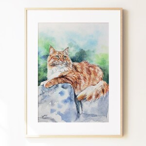 May include: A framed watercolor painting depicting a long-haired ginger and white cat resting on a large, cool-toned stone. The cat has green eyes and is looking toward the upper right. The background features soft, blended washes of green and blue.