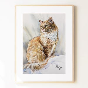 May include: A framed watercolor painting of a long-haired ginger cat with a white chest and green eyes, sitting in a profile pose. The artwork features a soft, neutral-toned background and includes the handwritten name Mojo in the lower right corner.