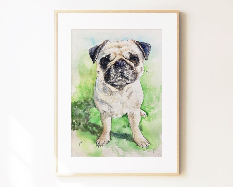 May include: A framed watercolor painting of a fawn-colored pug with a black muzzle and dark ears. The dog is standing against a soft, blended green and blue background. The artwork is enclosed in a simple, light-colored wooden frame with a white mat.