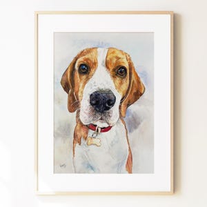 May include: A framed watercolor painting of a beagle dog with brown and white fur, wearing a red collar with a bone-shaped tag. The dog is depicted from the chest up, facing forward with dark eyes and a black nose, set against a soft wash background.