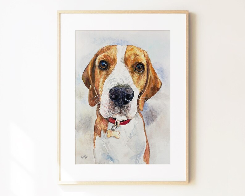 May include: A framed watercolor painting of a beagle dog with brown and white fur, wearing a red collar with a bone-shaped tag. The dog is depicted from the chest up, facing forward with dark eyes and a black nose, set against a soft wash background.