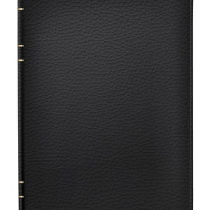 Puede incluir: Un diario o cuaderno negro encuadernado en cuero con una superficie texturizada. La cubierta presenta un borde cosido y detalles dorados a lo largo del lomo. El diario es rectangular y parece cerrado.