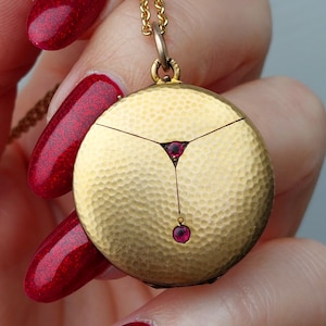 Medalhão de ouro com superfície texturizada Art Nouveau e pastas de rubi vermelho