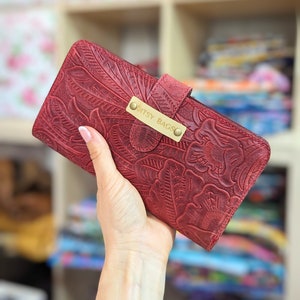 Cartera para teléfono de piel repujada con ranuras para tarjetas y billetes personalizable en varios tipos de piel y forros.
