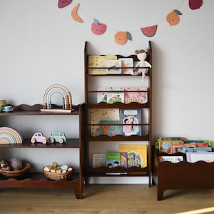 a wall mounted bookcase in dark brown stain with a wavy decor