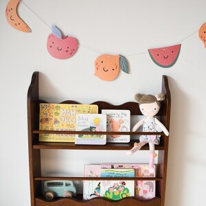 a wall mounted bookcase in dark brown stain with a wavy decor