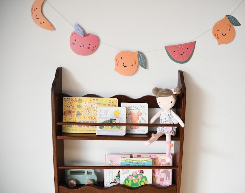 a wall mounted bookcase in dark brown stain with a wavy decor