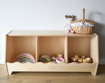 a toy cubby shelf with wavy decor, a boho nursery toy shelf with scallops