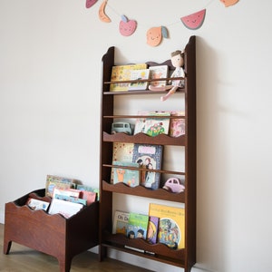 a wall mounted bookcase in dark brown stain with a wavy decor