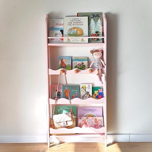 en vägghängd rosa Montessori-bokhylla till barnrummet