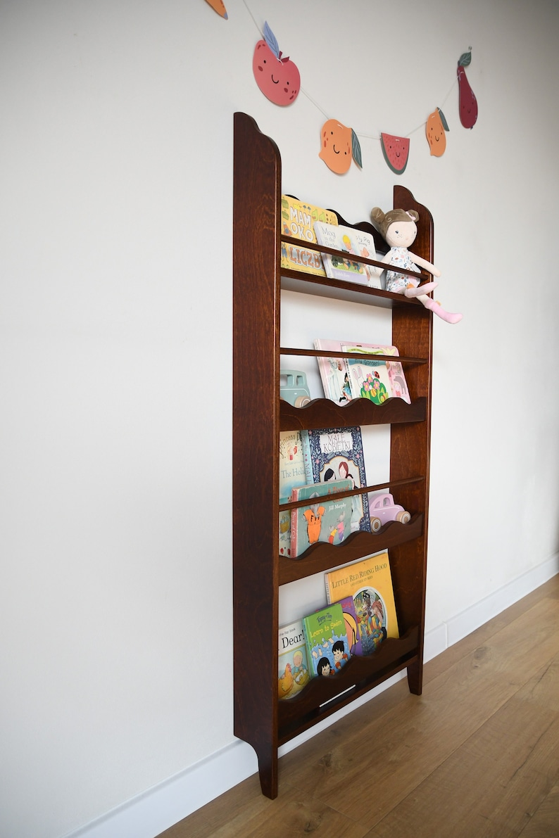 a wall mounted bookcase in dark brown stain with a wavy decor