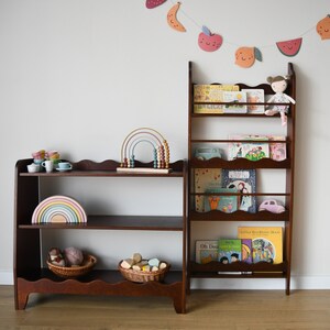 a wall mounted bookcase in dark brown stain with a wavy decor
