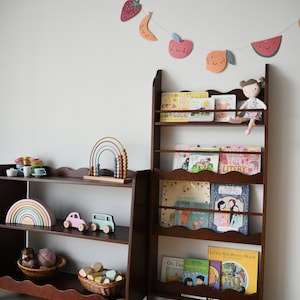 a wall mounted bookcase in dark brown stain with a wavy decor