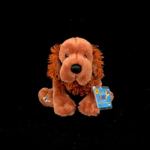 May include: A brown and orange Webkinz plush toy dog with a tag that says "Webkinz Discover a virtual world".