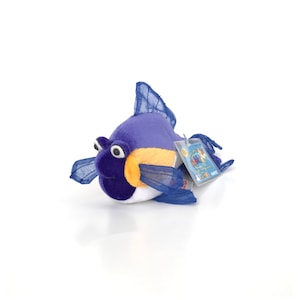 Puede incluir: Un juguete de peluche de pescado morado y amarillo con vientre blanco y aletas azules. El juguete tiene una etiqueta adjunta que dice "Webkinz"