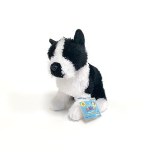May include: Black and white Webkinz plush dog with a blue tag that says "Webkinz Discover a virtual world" and "Code inside".