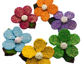 Könnte beinhalten: Sechs bunte Filzblumen mit Glitzerakzenten. Jede Blume hat eine weiße Mitte und ist an einem grünen Filzblatt befestigt.