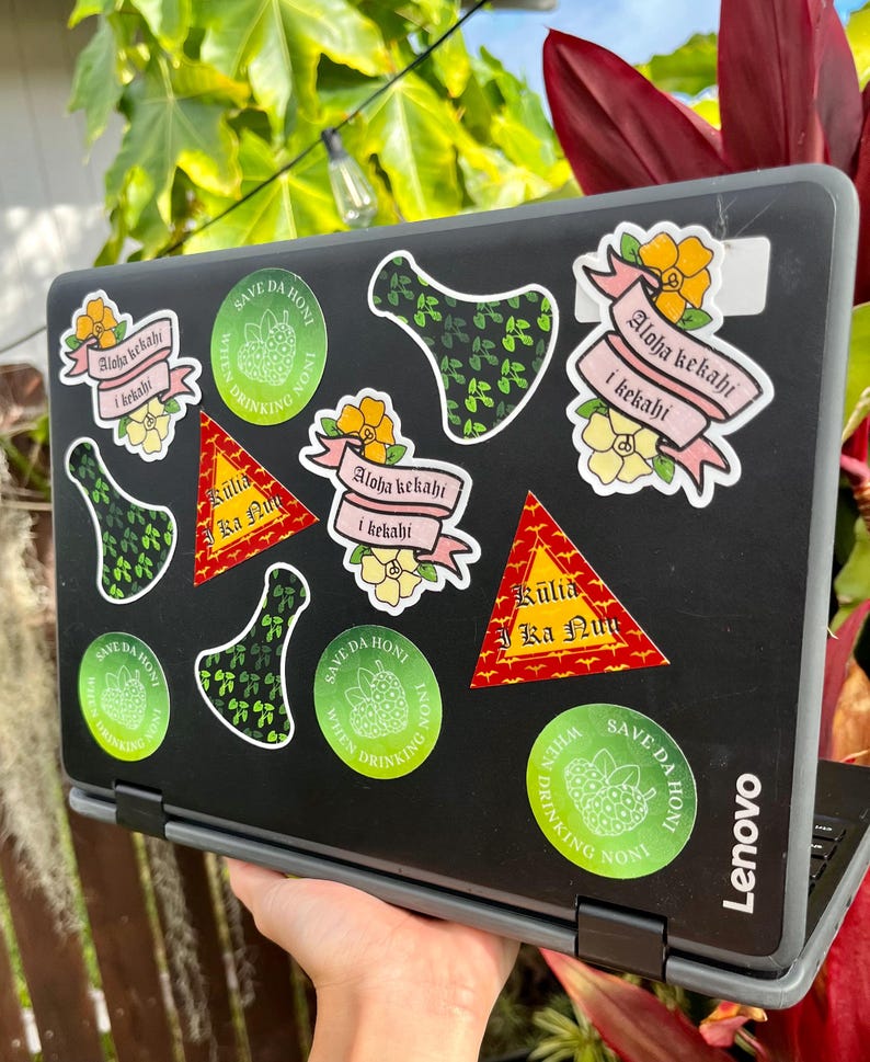 May include: A laptop computer covered in stickers. The stickers are mostly green and feature a tropical plant design. Some stickers have text that says "Save Da Hon" and "Aloha Kekahi I Kekahi".