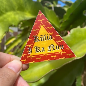 May include: A red triangular sticker with a yellow center and a pattern of red bats. The sticker says "Kuli'a I Ka Nu'u" in black lettering.