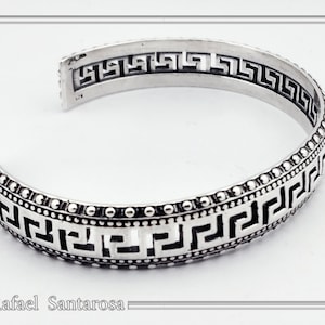 Sterling silver cuff bracelet with a string of Greek meander or Greek key design and oxidized silver granulation decoration. Greek museum.