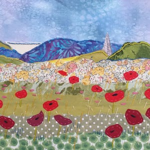 May include: A colourful fabric art piece depicting a field of red poppies with a distant mountain range in the background.