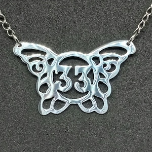 May include: A silver butterfly necklace with a detailed design and the number 33 in the centre.
