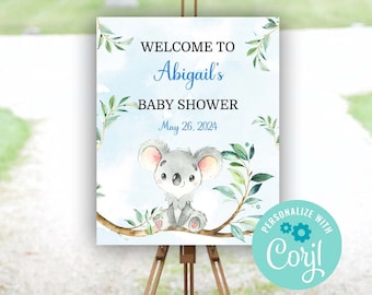 Op de afbeelding: Welkom op Abigail's Baby Shower bord met een schattige koalabeer illustratie, blauwe en groene aquarelbladeren en een lichtblauwe achtergrond. Het bord staat op een houten ezel en heeft de datum 26 mei 2024. Het bord heeft ook een gepersonaliseerd logo met de tekst "Personaliseer met CORYL".