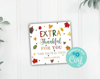 May include: A white printable gift tag with fall-themed graphics and the text "EXTRA Thankful FOR YOU" and "THANK YOU FOR ALL YOU DO! FROM: CHARLEE". The tag also includes a blue circle with the text "PERSONALIZE WITH Coryl".