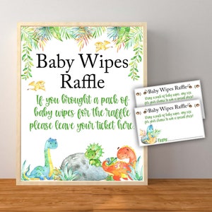 May include: A sign with a green and white dinosaur theme for a baby wipes raffle. The sign says "Baby Wipes Raffle" and "If you brought a pack of baby wipes for the raffle please leave your ticket here." There are two smaller tickets that say "Baby Wipes Raffle" and "Bring a pack of baby wipes, any size, for your chance to win a special prize!"