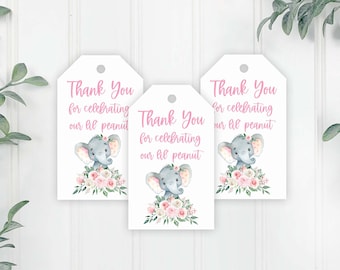 May include: Three white thank you tags with pink text and a watercolour illustration of a grey elephant with pink flowers. The text on the tags reads "Thank You for celebrating our lil peanut".