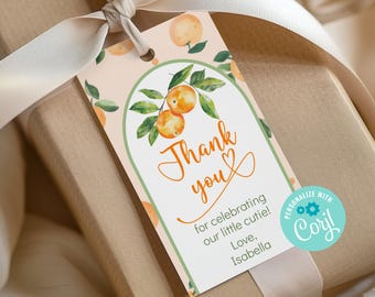 Puede incluir: Una etiqueta de regalo con un diseño de acuarela naranja y verde, con el texto "Thank you" en escritura naranja. La etiqueta está atada a un regalo envuelto con una cinta crema. El texto "for celebrating our little cutie! Love, Isabella."
