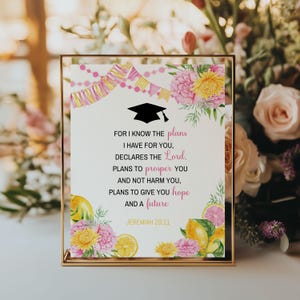 May include: A framed print with a graduation cap illustration and the text "For I know the plans I have for you, declares the Lord. Plans to prosper you and not harm you, plans to give you hope and a future. Jeremiah 29:11." Floral accents.
